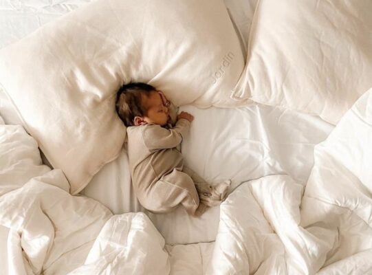 baby with blanket and pillows